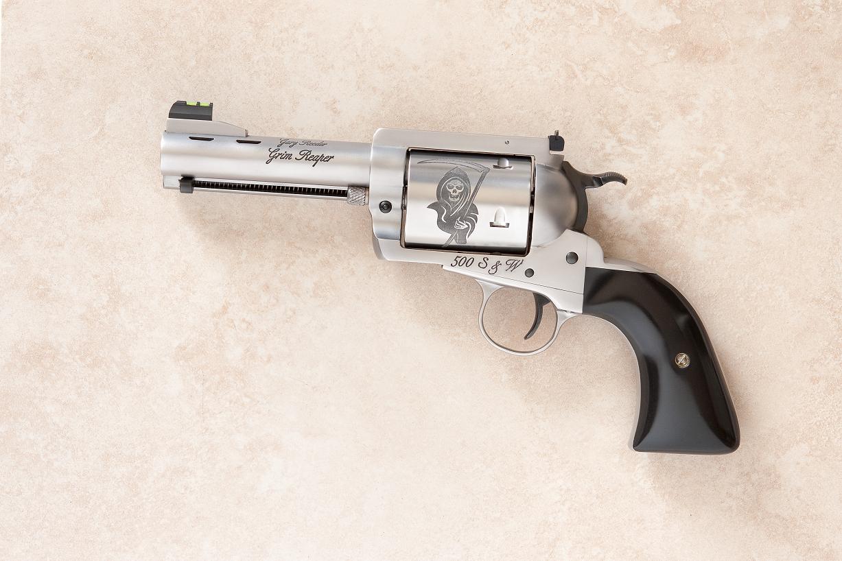 A gun that is on the ground with its side open.
