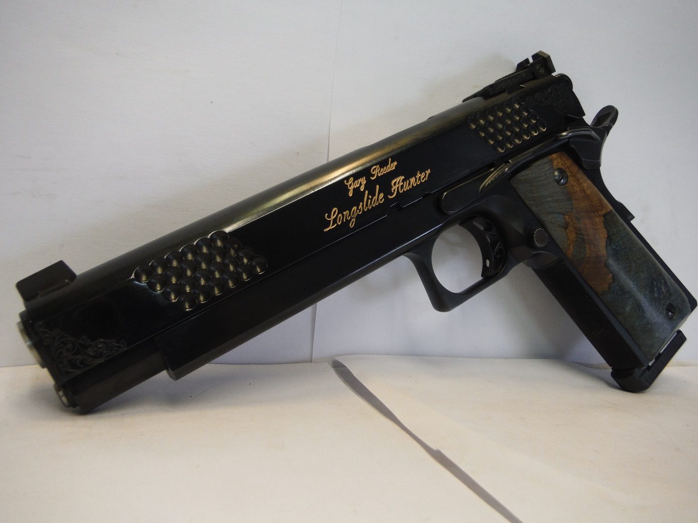 10-2 (8) A black gun with a wooden handle on top of it.