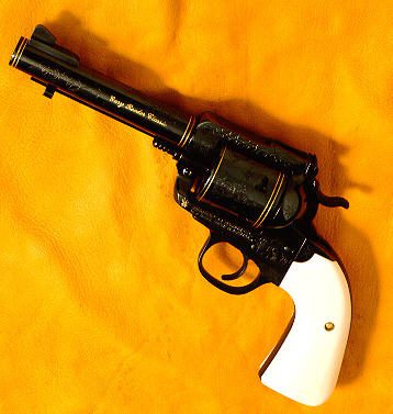 13 A black and white revolver is on the yellow blanket.