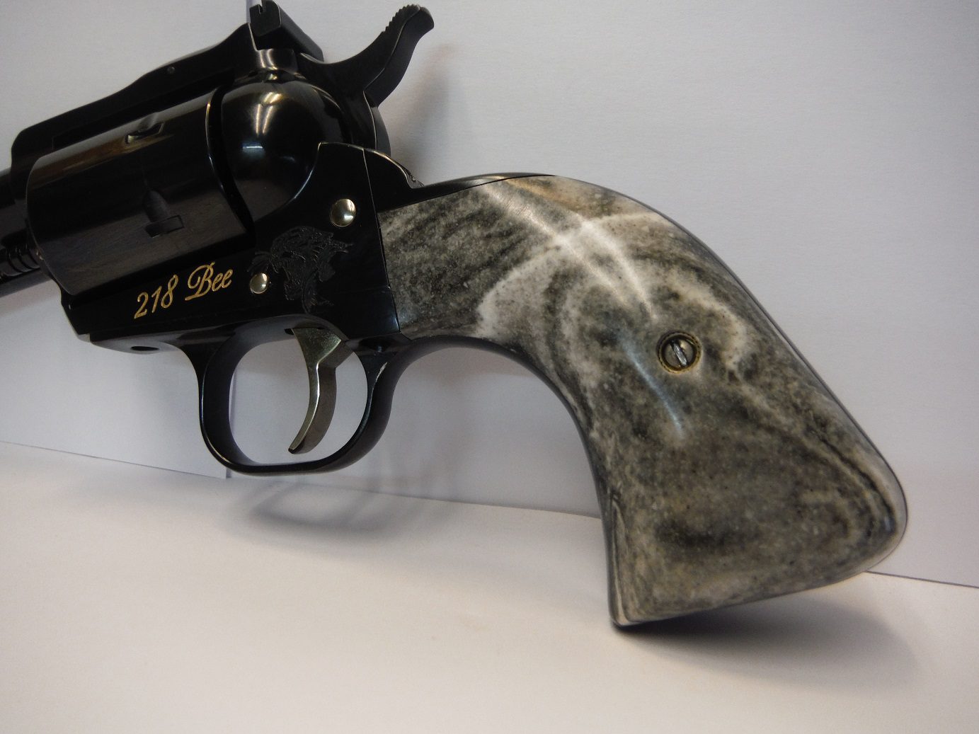 A gun that is on the ground with its handle up.