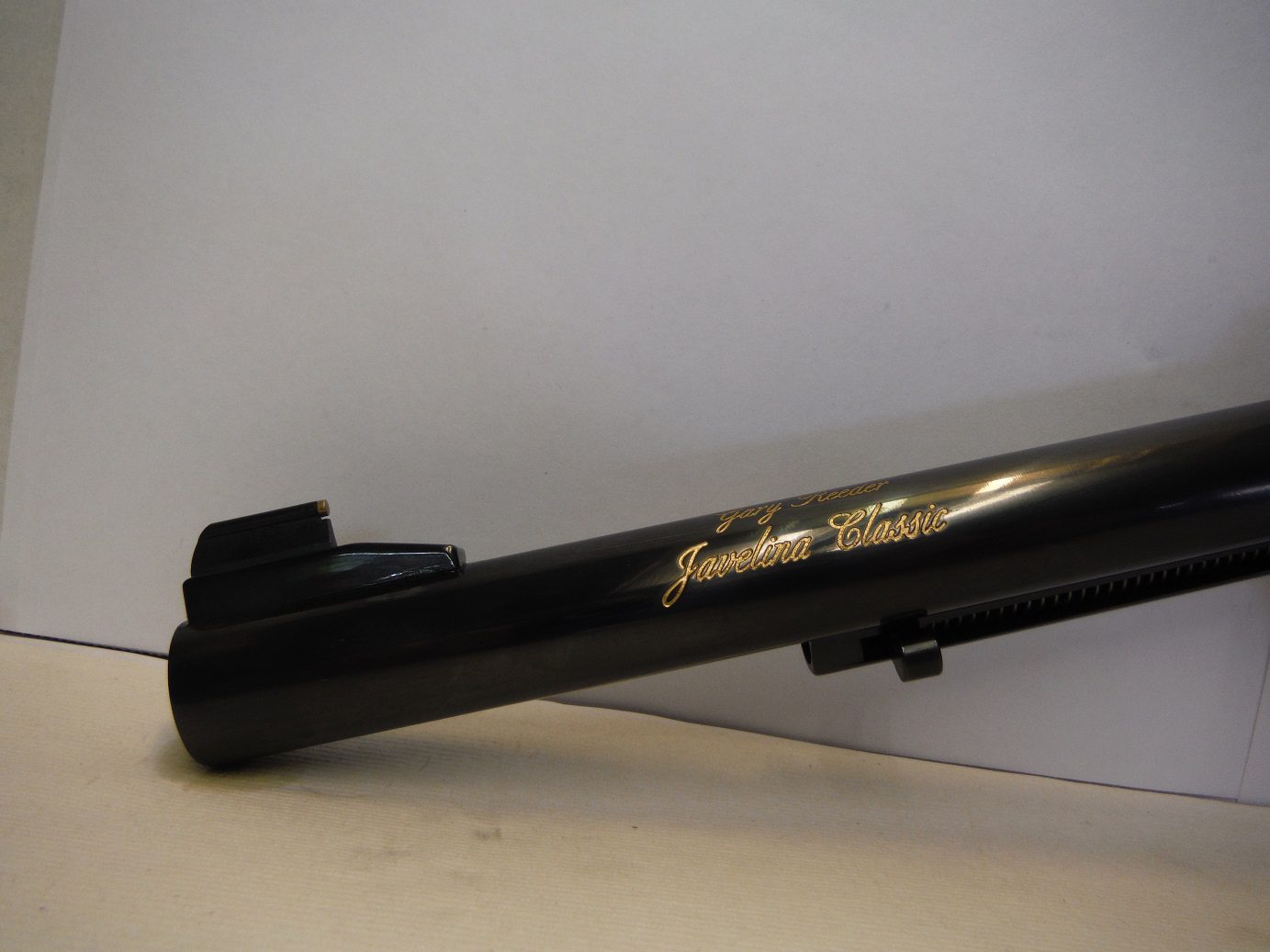 A black gun with gold writing on it.