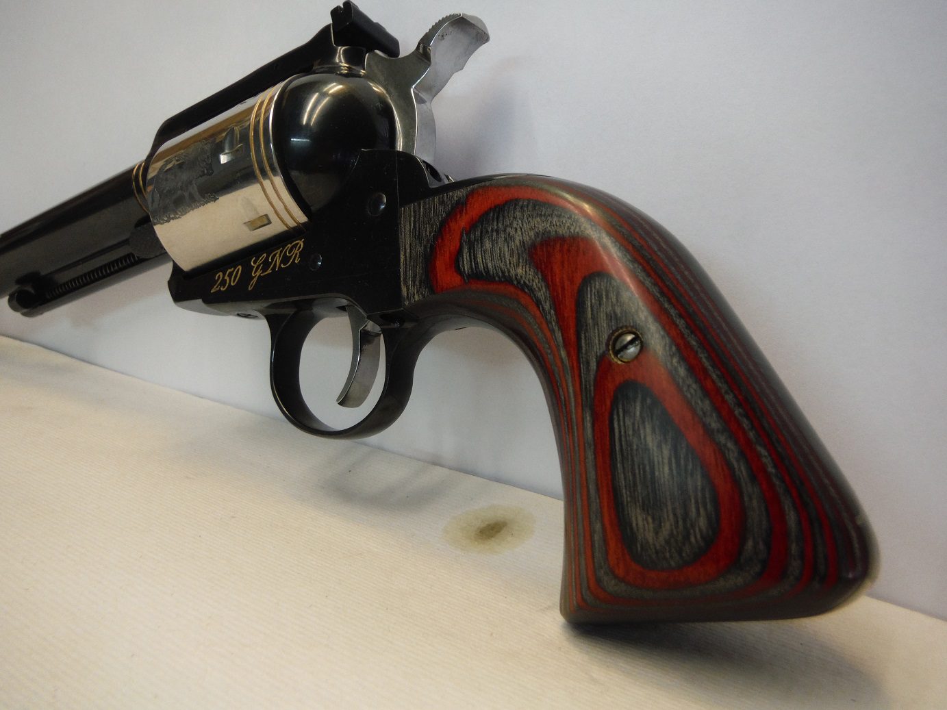 A gun that is on the wall and has some wood grain