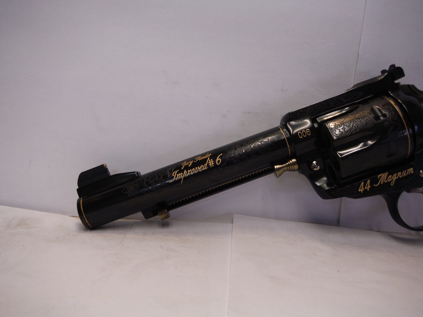 A black and gold gun is sitting on the floor
