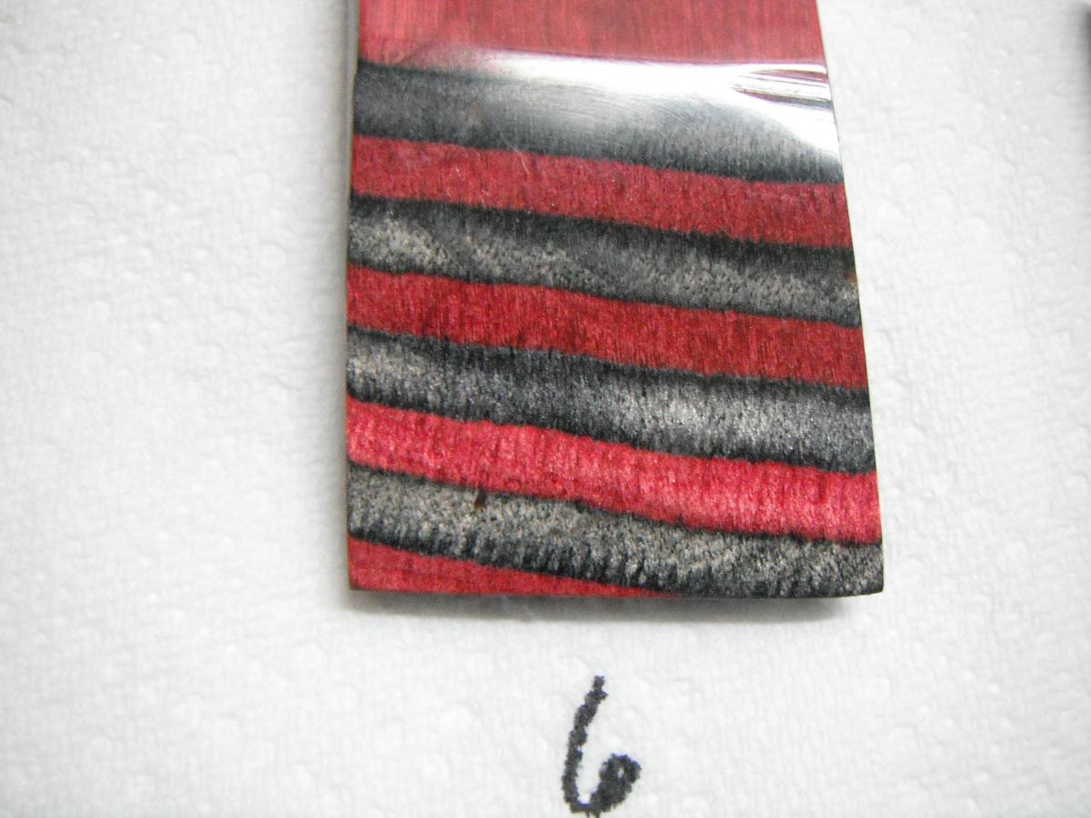 A red and black striped tie with a hook on it.