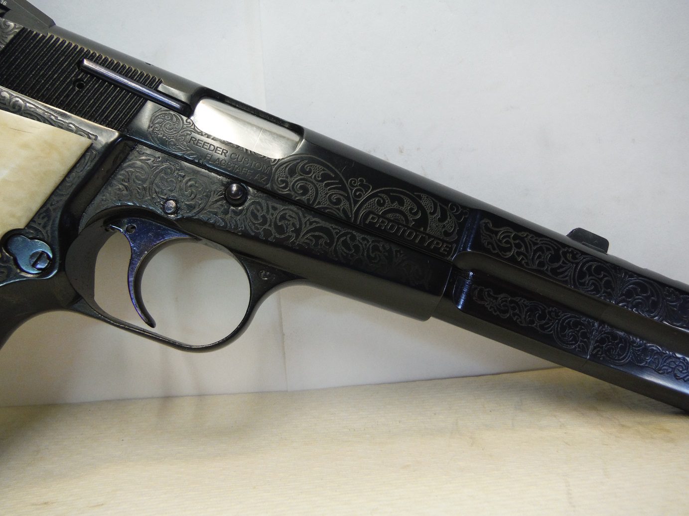 A black gun with blue accents on top of a table.