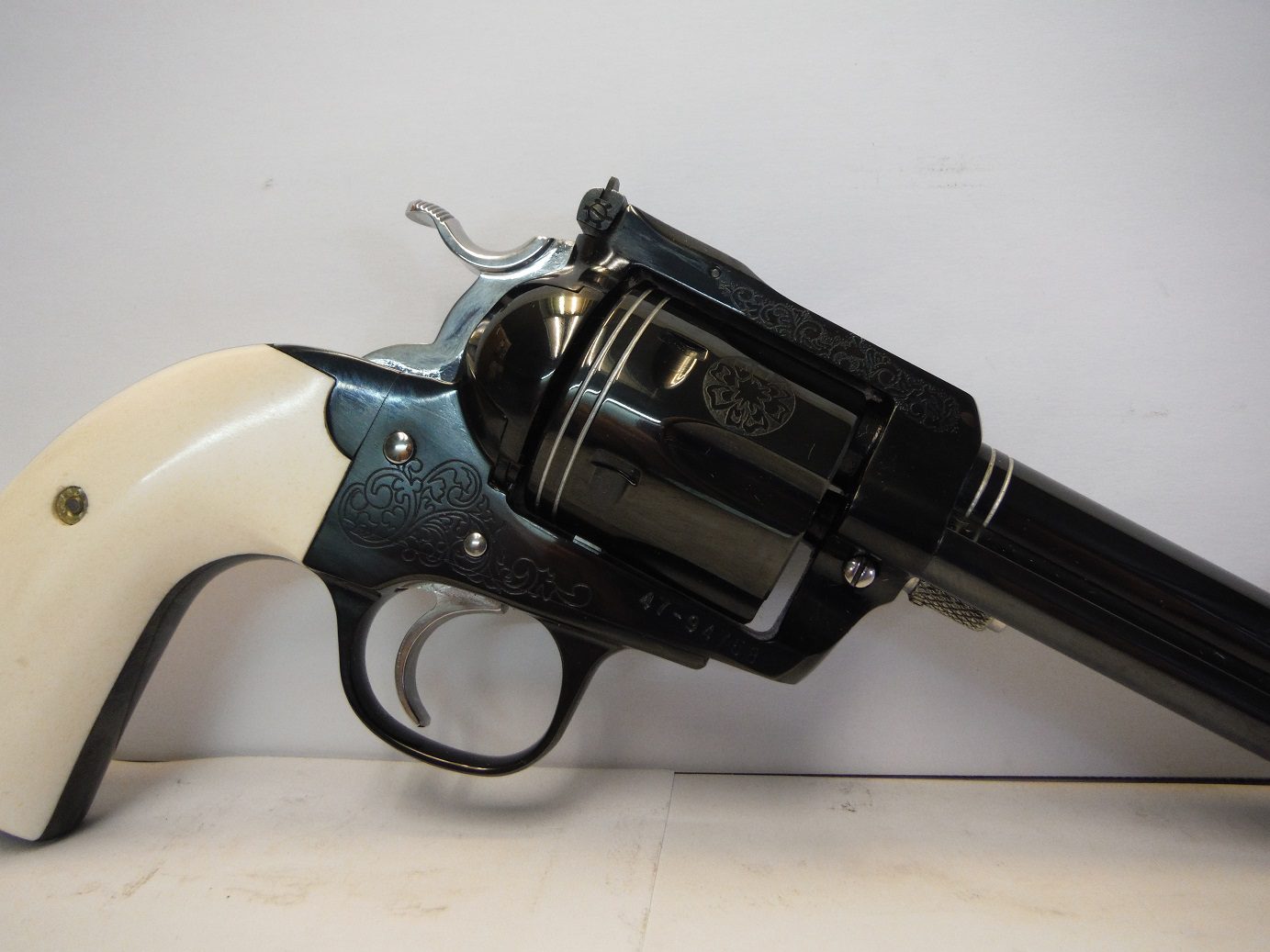 A black revolver with white handle and black barrel.