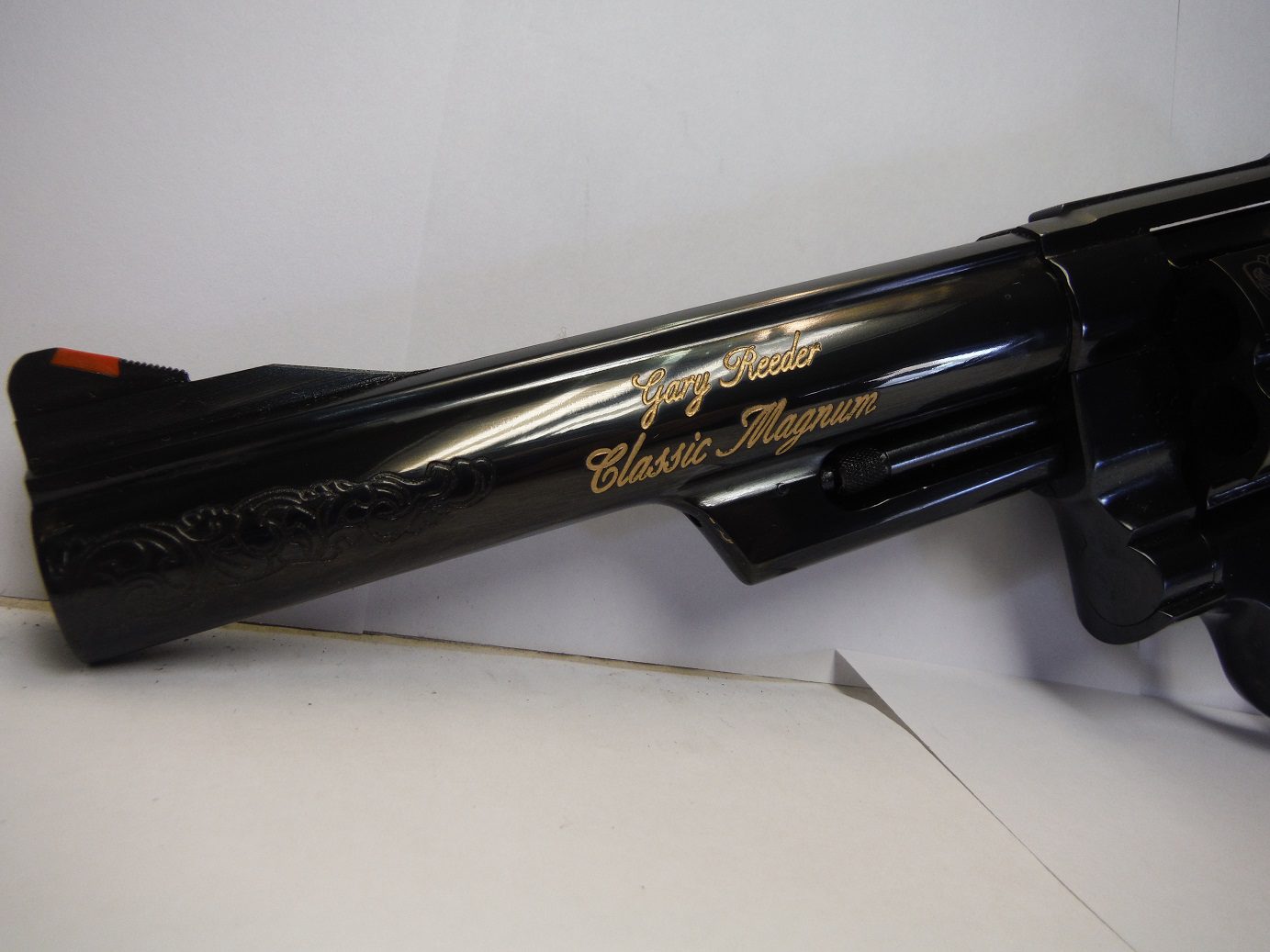 A black gun with gold writing on it.