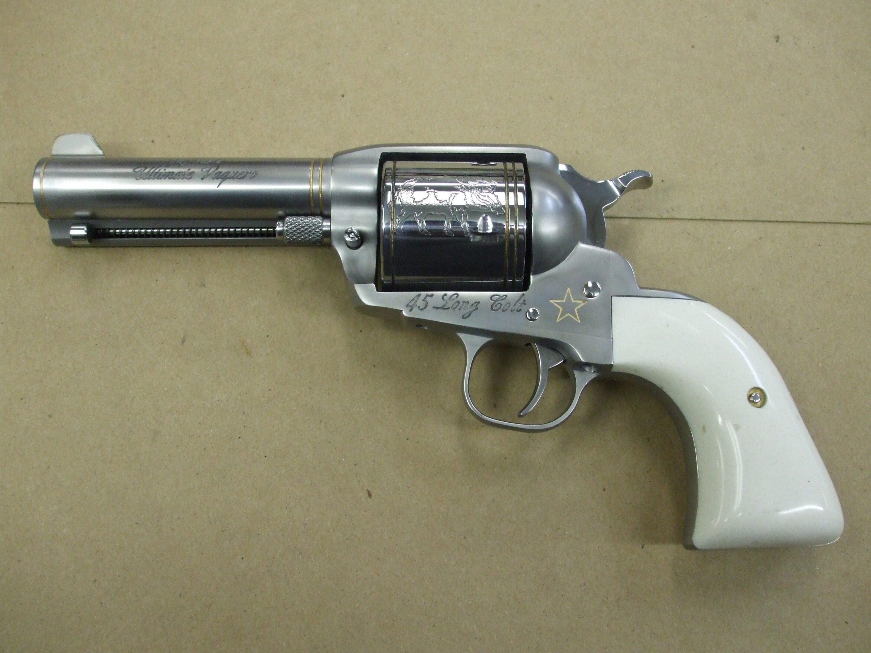 A white handle and silver gun on top of a table.