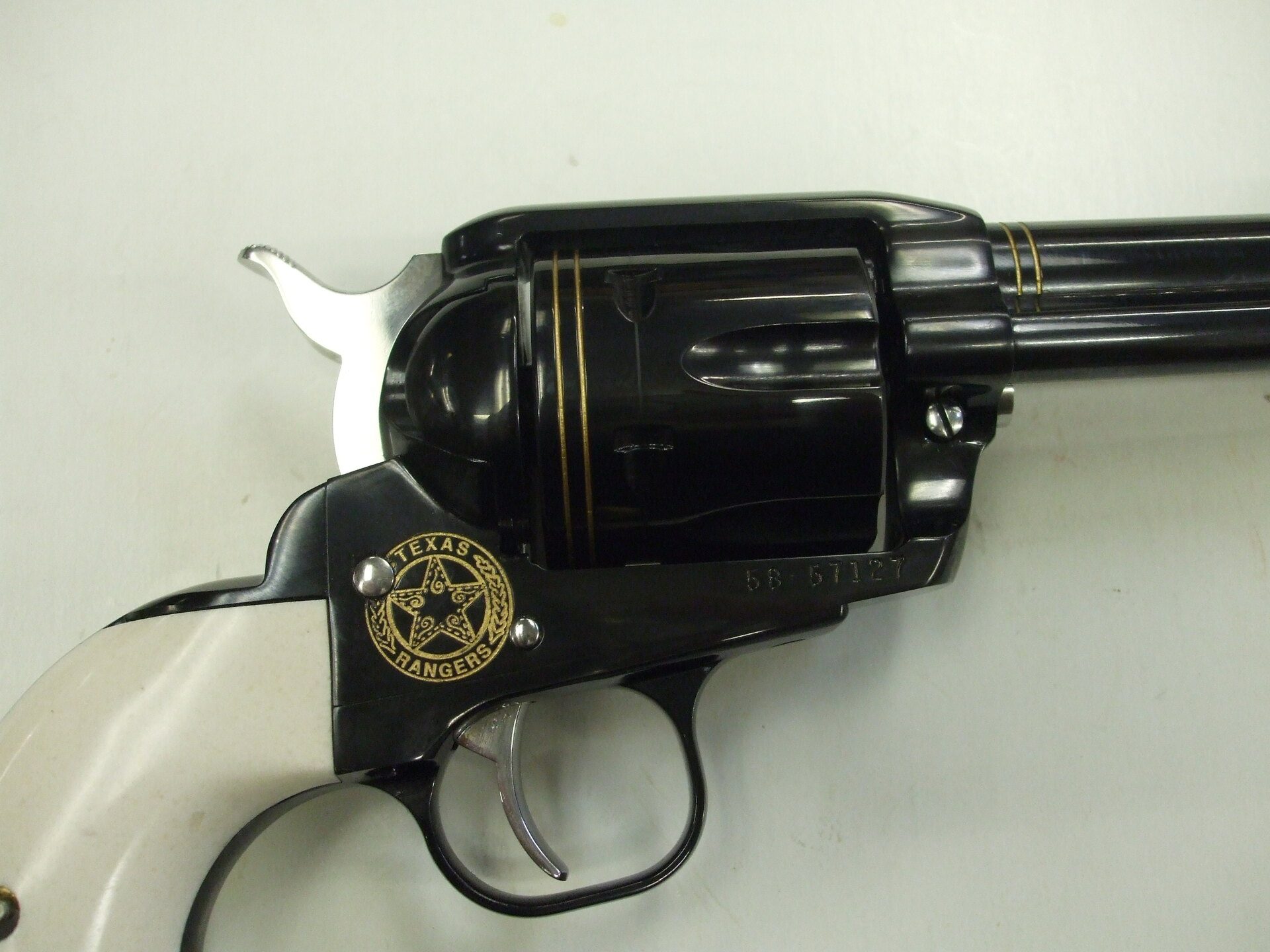 A black and white gun with a gold emblem on it.