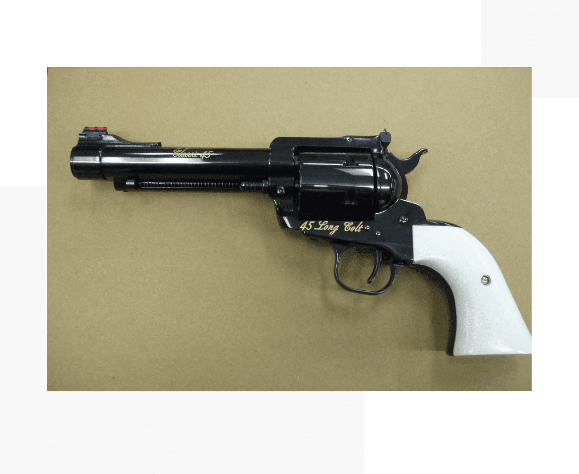 A black and white gun is hanging on the wall