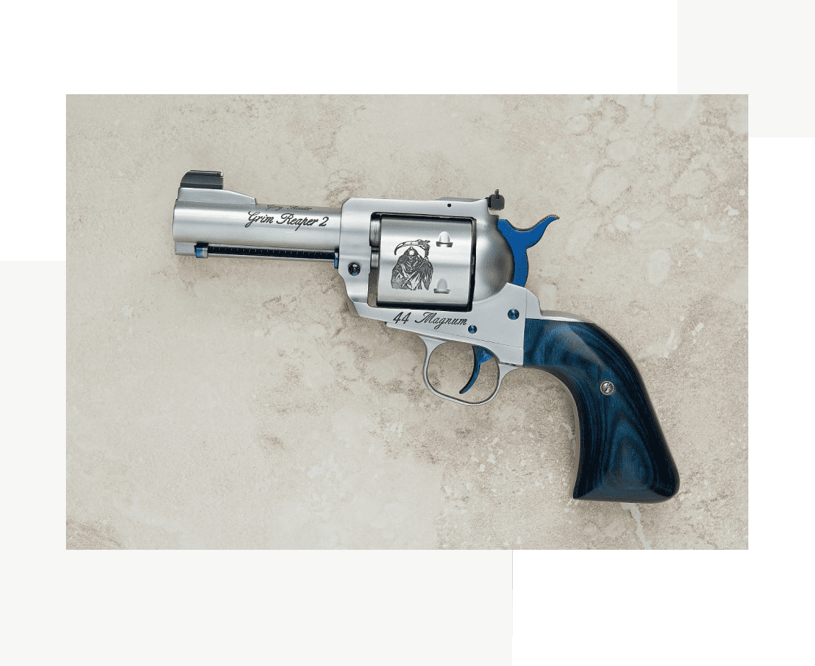 Group 36 A silver and blue gun is laying on the ground.