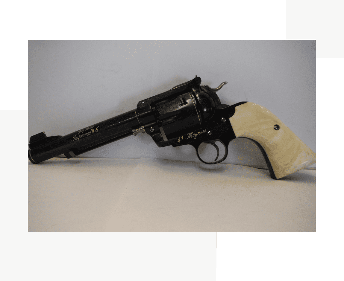 Group 45 A gun with a white handle is sitting on the ground.