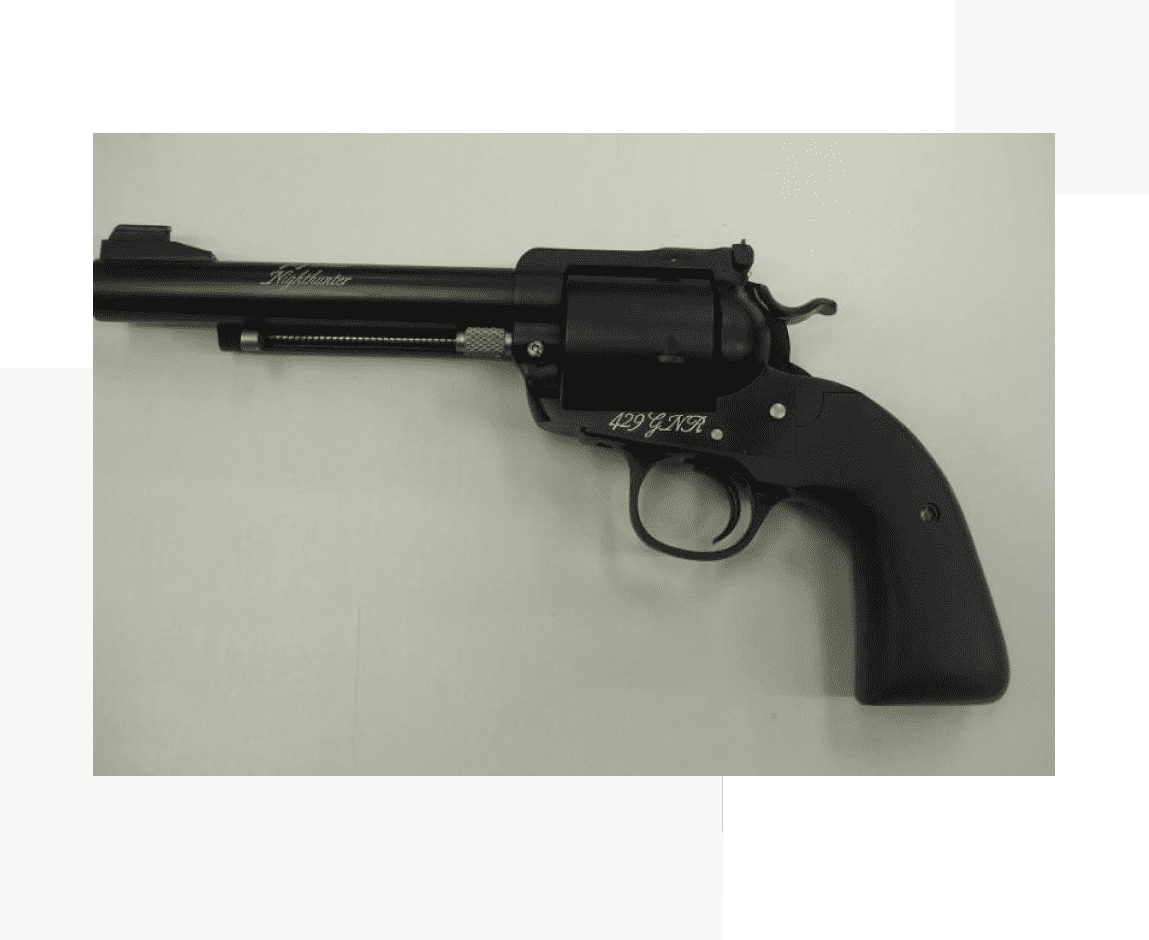 Group 47 A black revolver is on display in front of a green background.