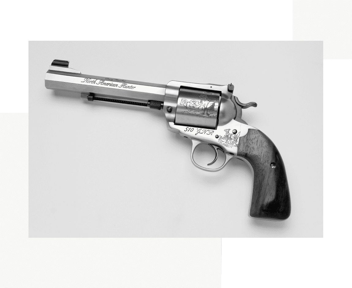 Group 48 A gun that is on the ground in front of a wall.