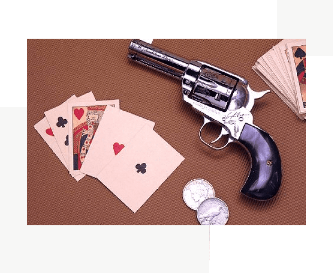 Group 67 A gun and playing cards on a table.