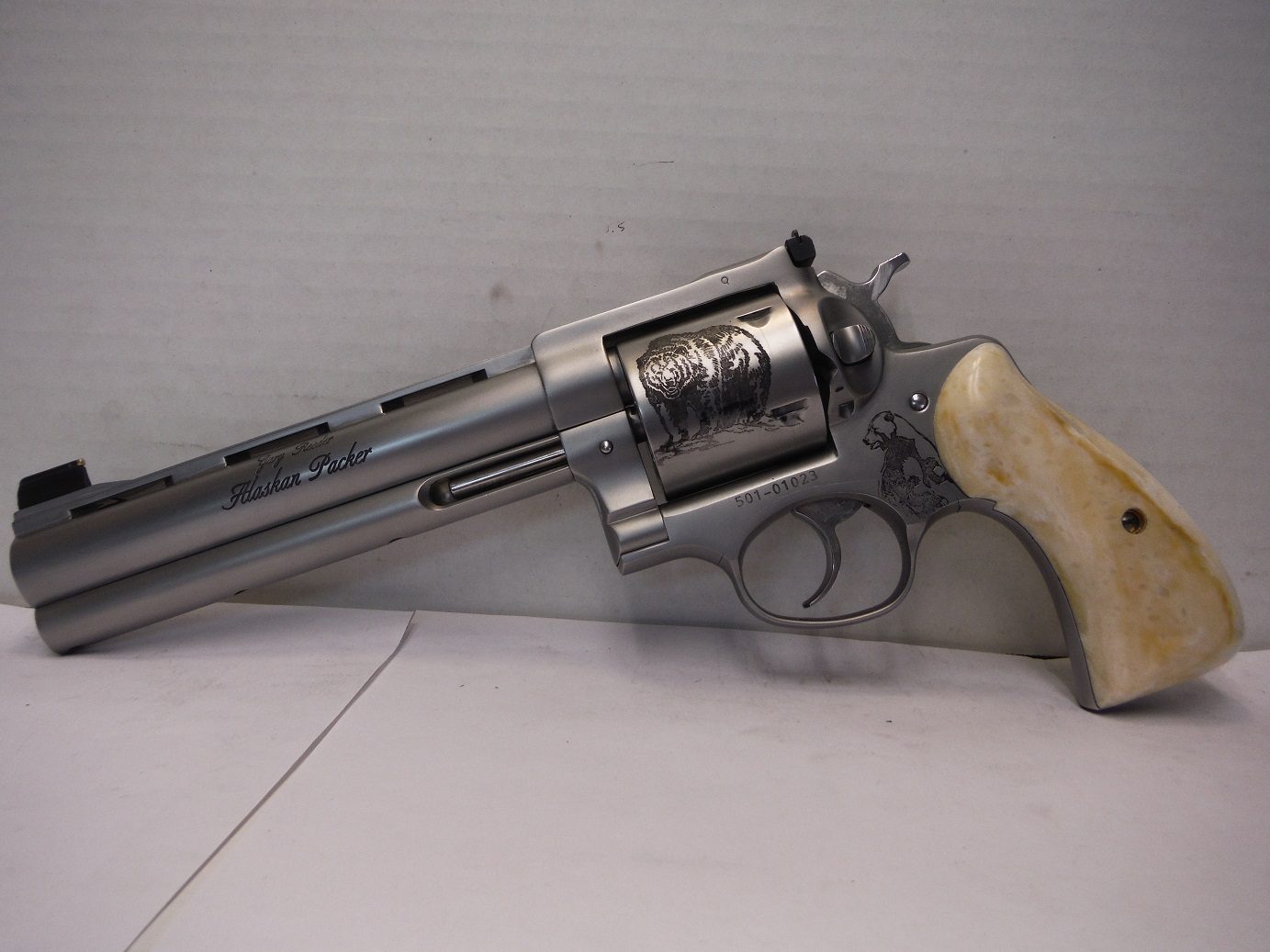 A silver and wood gun is sitting on top of a table.