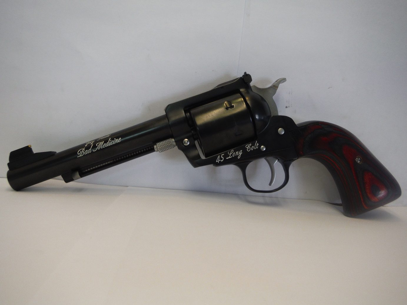A black revolver with a red handle on top of it.