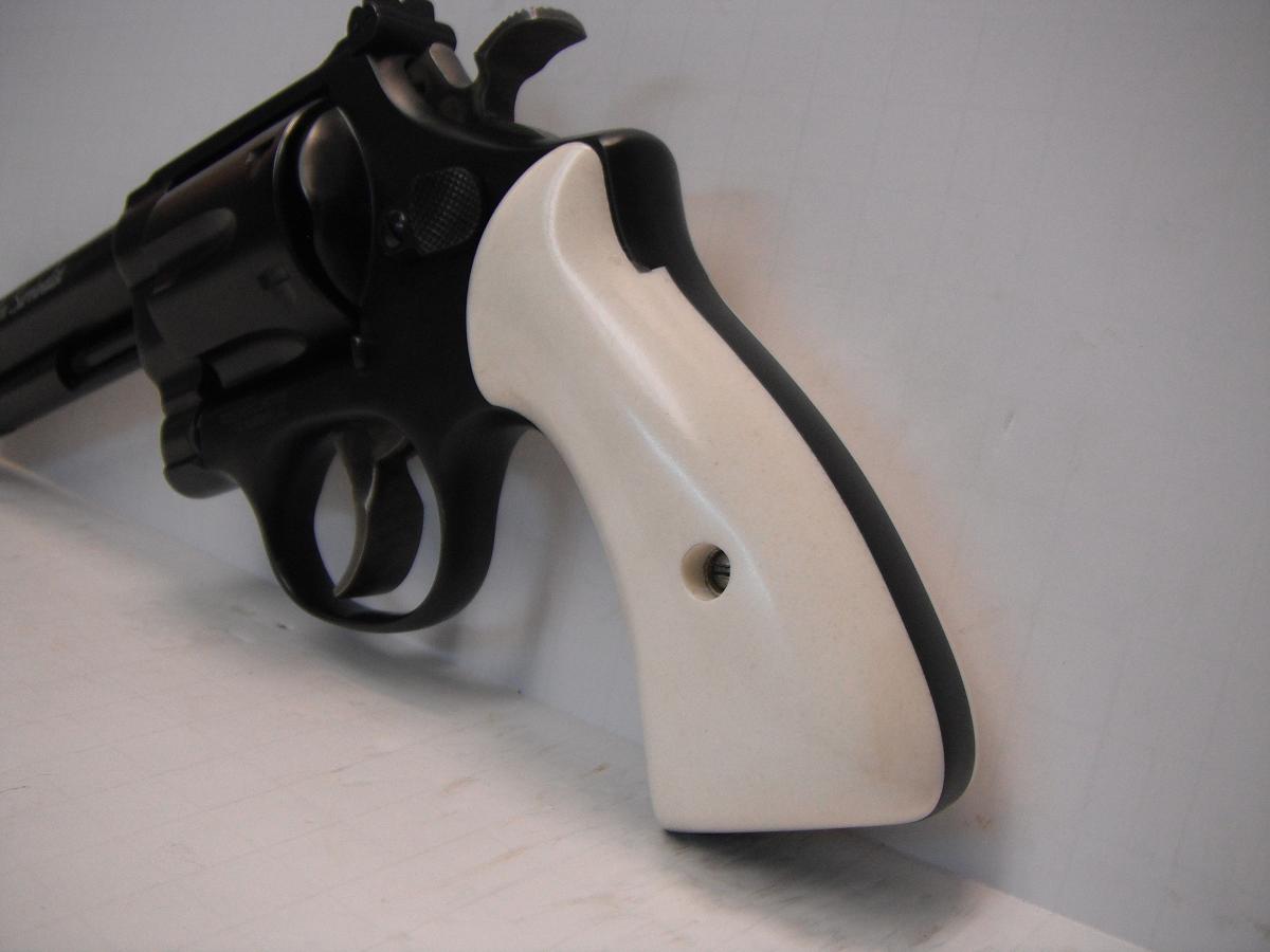 A white and black gun is hanging on the wall