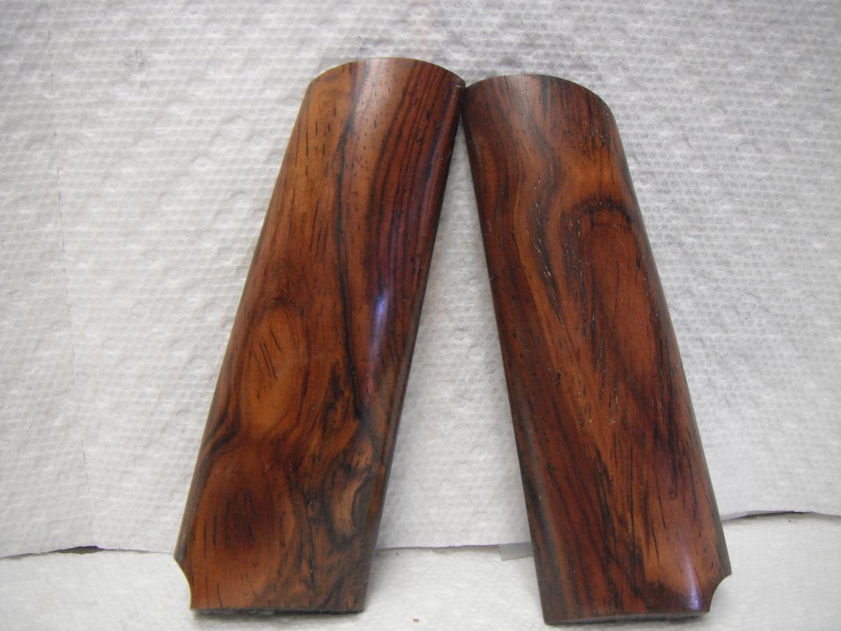 A pair of wooden handles for a gun.