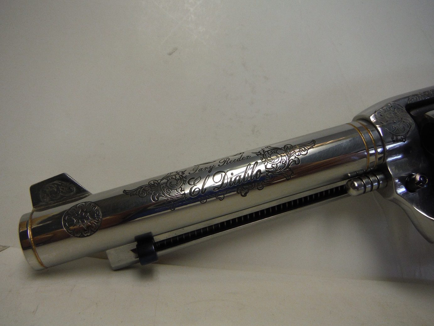 A silver tube with a black handle on top of it.