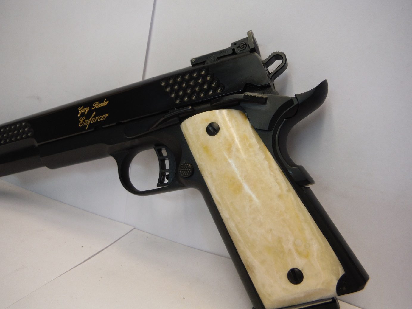 A black gun with a white handle on the side.