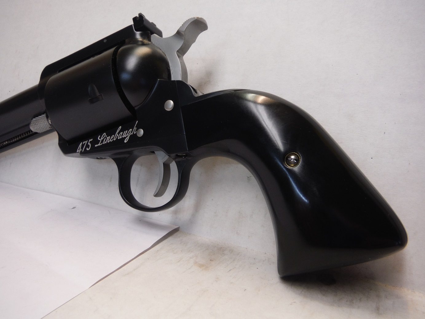 A black gun is laying on the floor