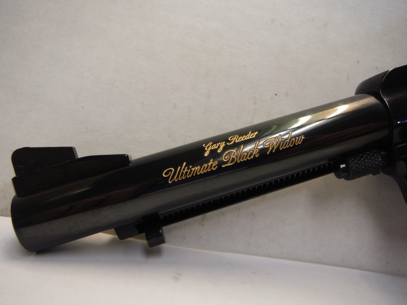 A black rifle with gold lettering on it.