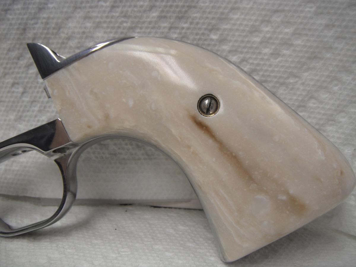 A white gun with a wooden handle on it.