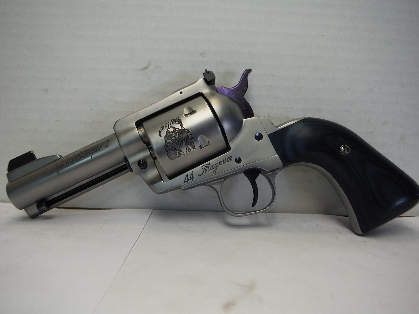 A silver and black revolver sitting on top of a table.