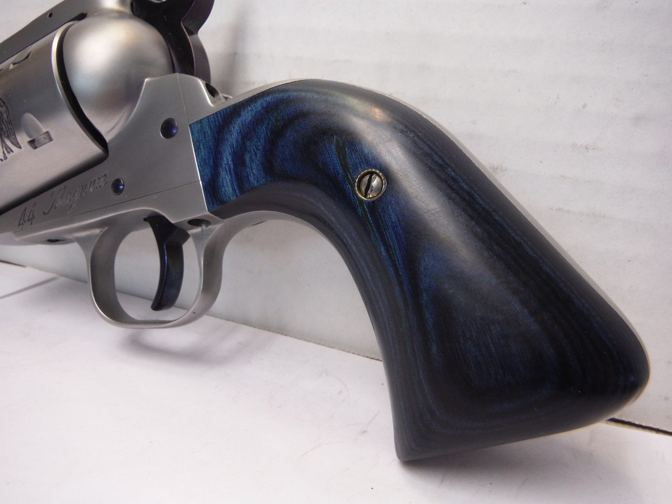 A close up of a gun with the handle turned down.