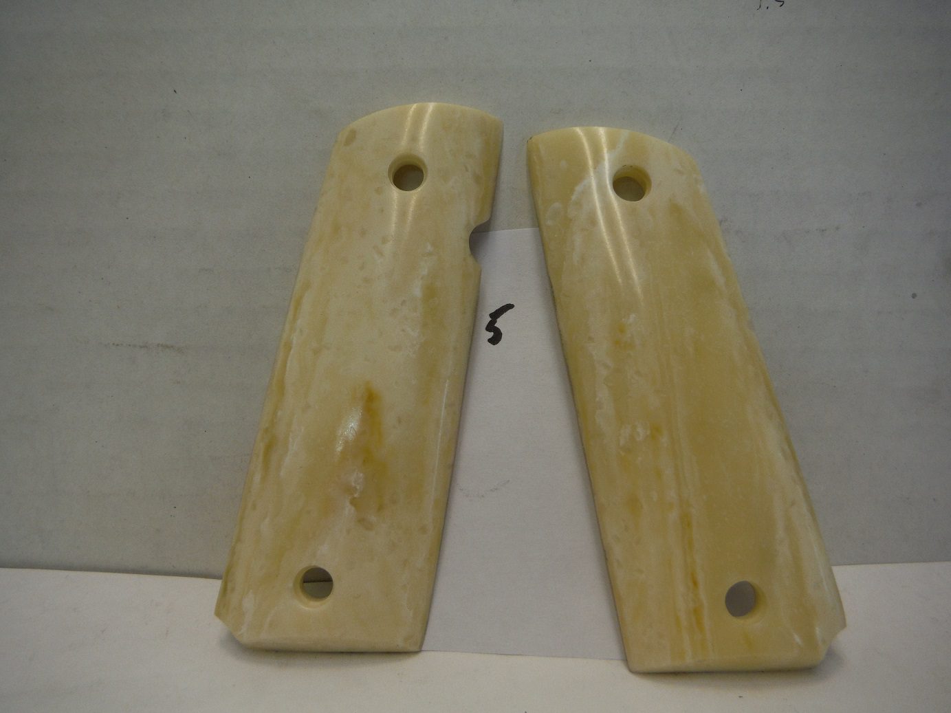 A pair of ivory colored wooden grips.