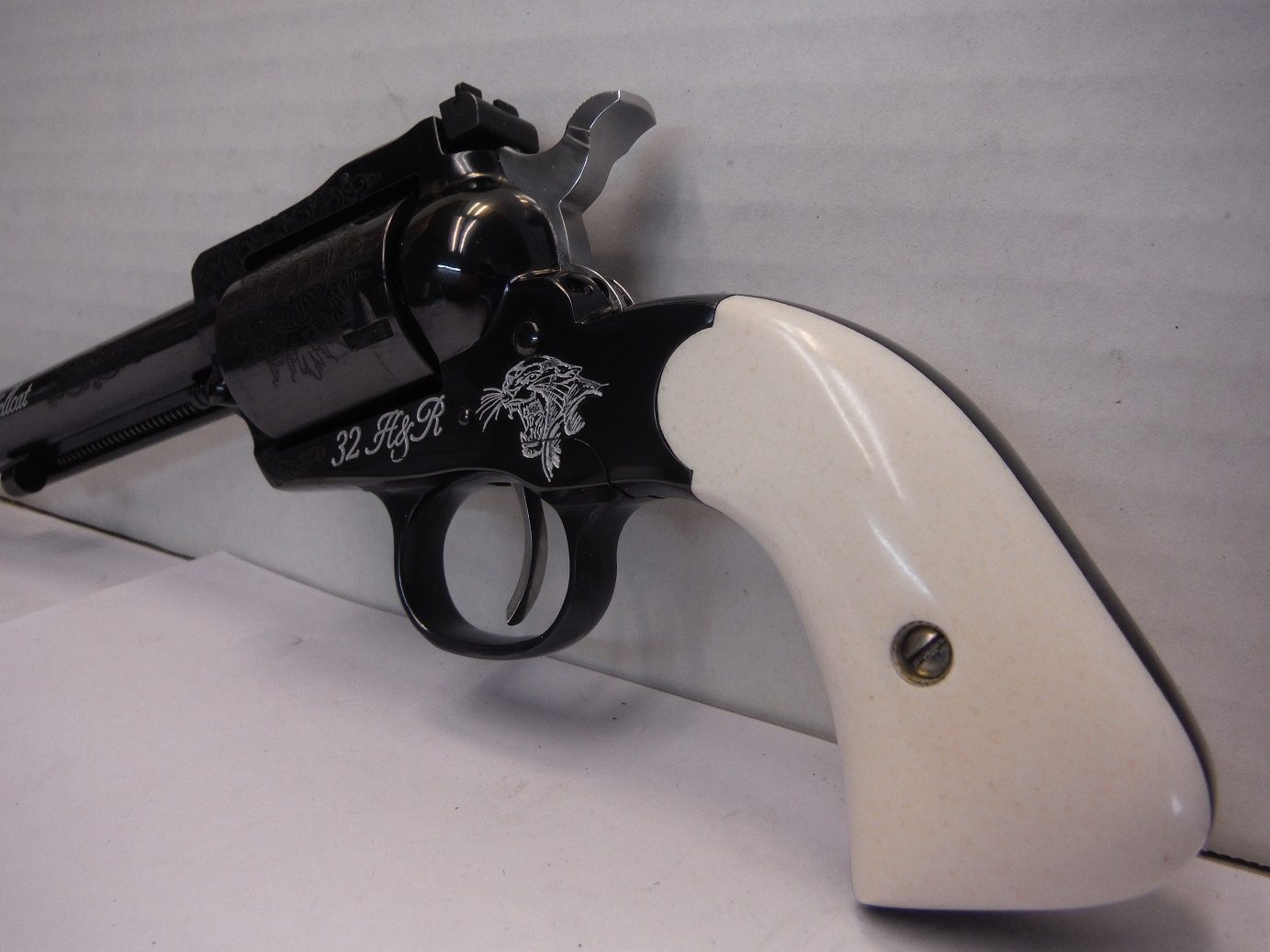 A white and black gun with a key chain attached.