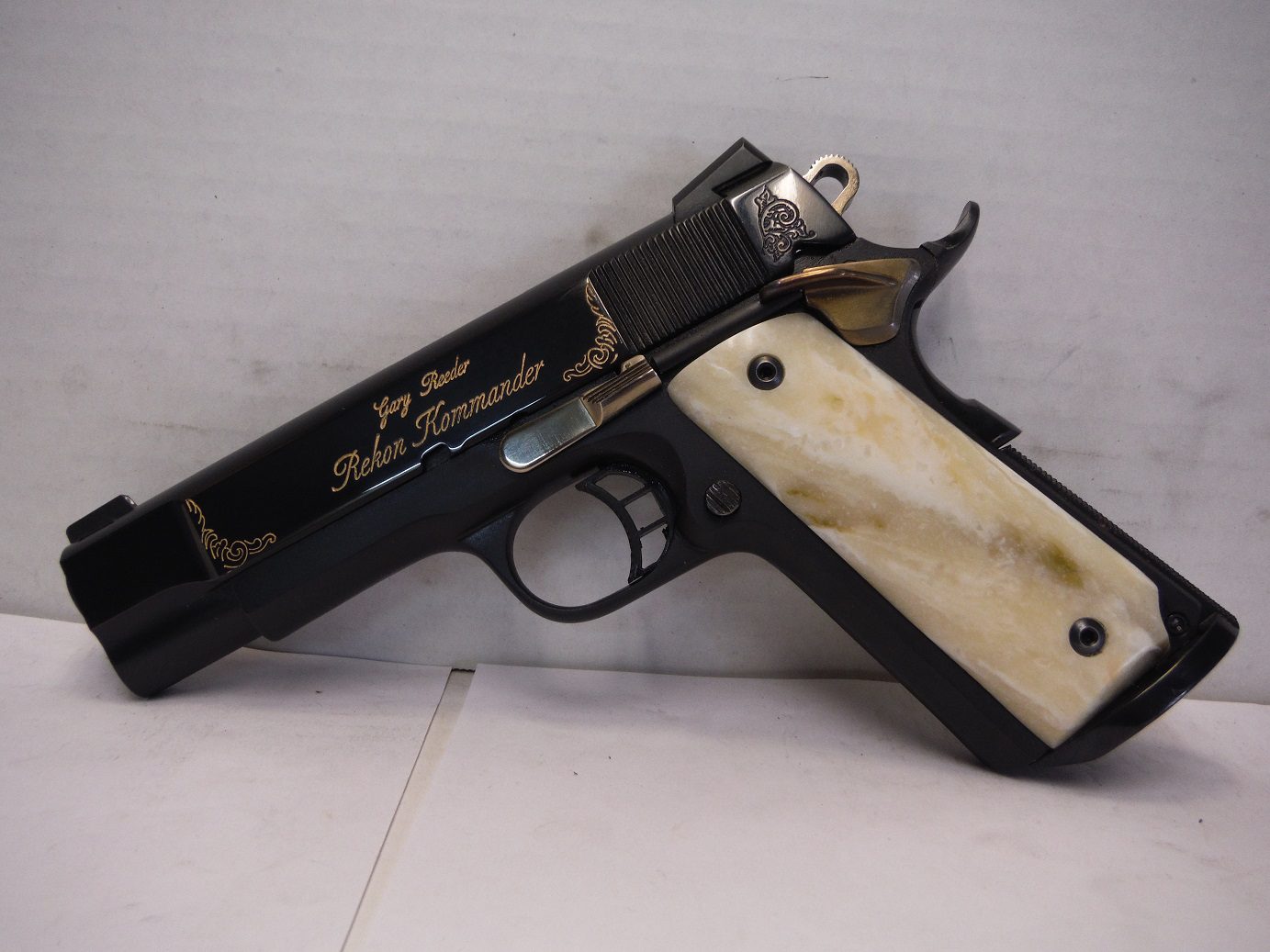 komman-1 A black and white gun with a bone handle.