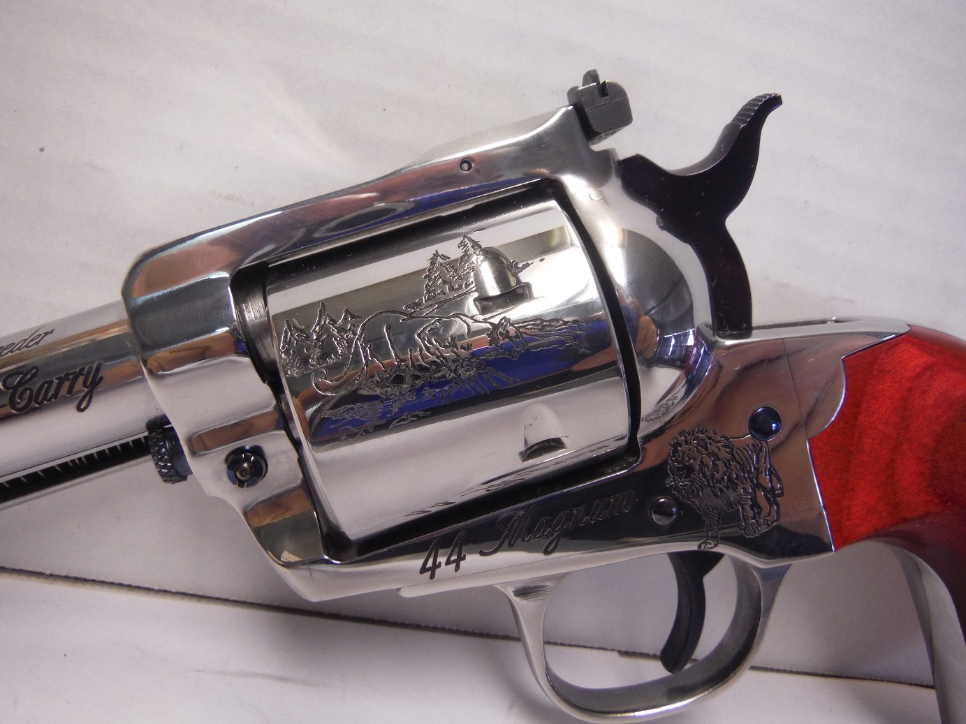 A silver gun with red handle and the words " wild west ".