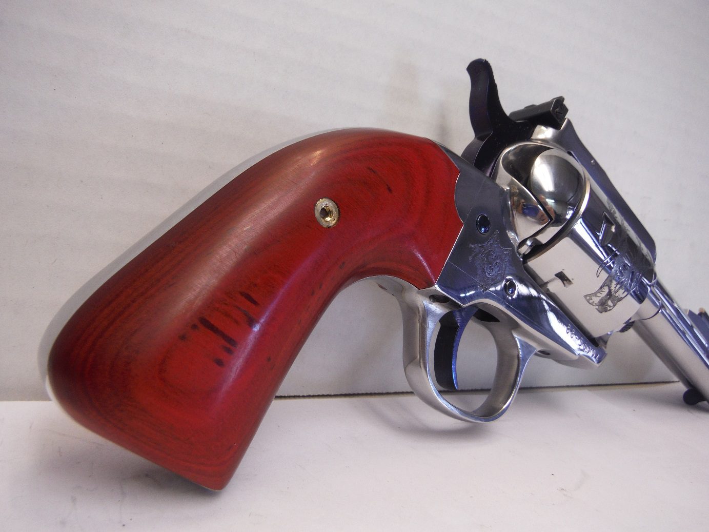 A red gun is laying on the counter