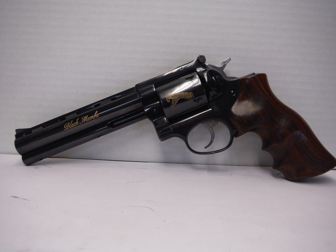 A black revolver with a wooden handle on the side.