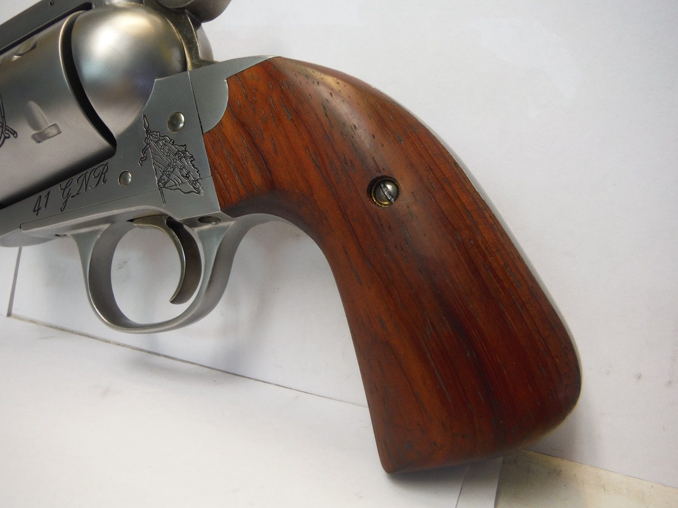 A close up of the wooden handle on a gun