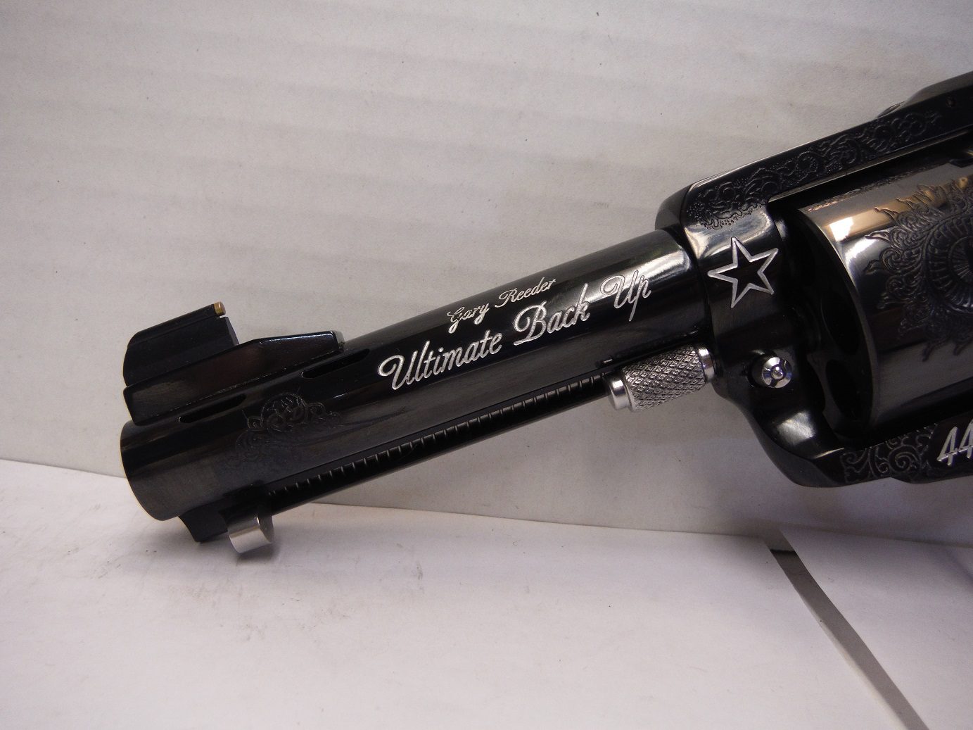 A black and silver gun sitting on top of a white table.