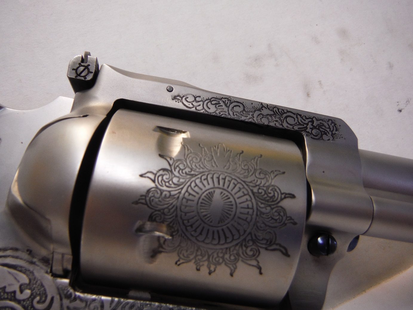 A close up of the engraved side of a gun