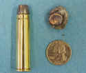 vest_small A bullet and some coins on a blue surface